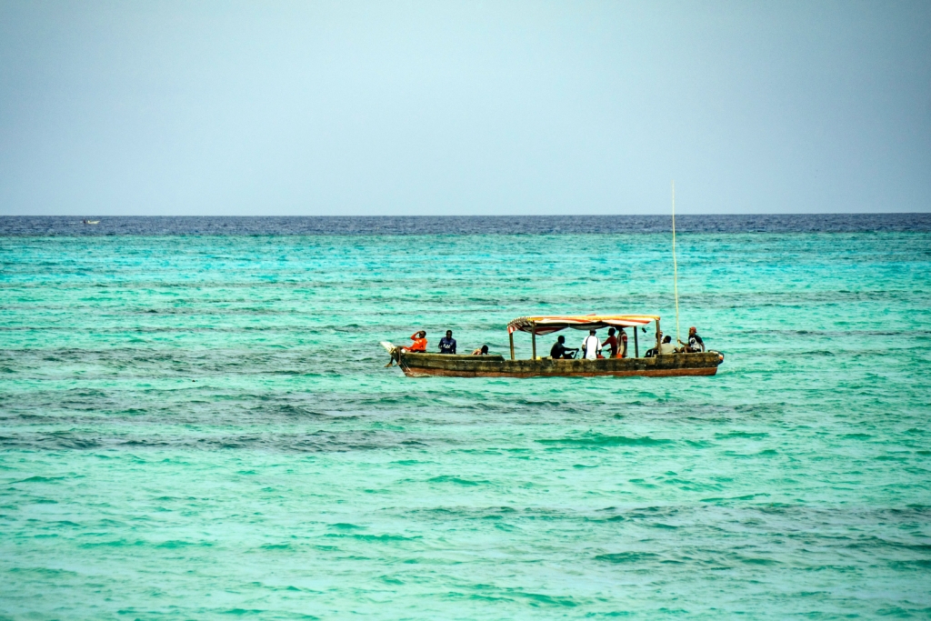 Marine researcher scanning the ocean surface with binoculars during a humpback whale survey in Mozambique
