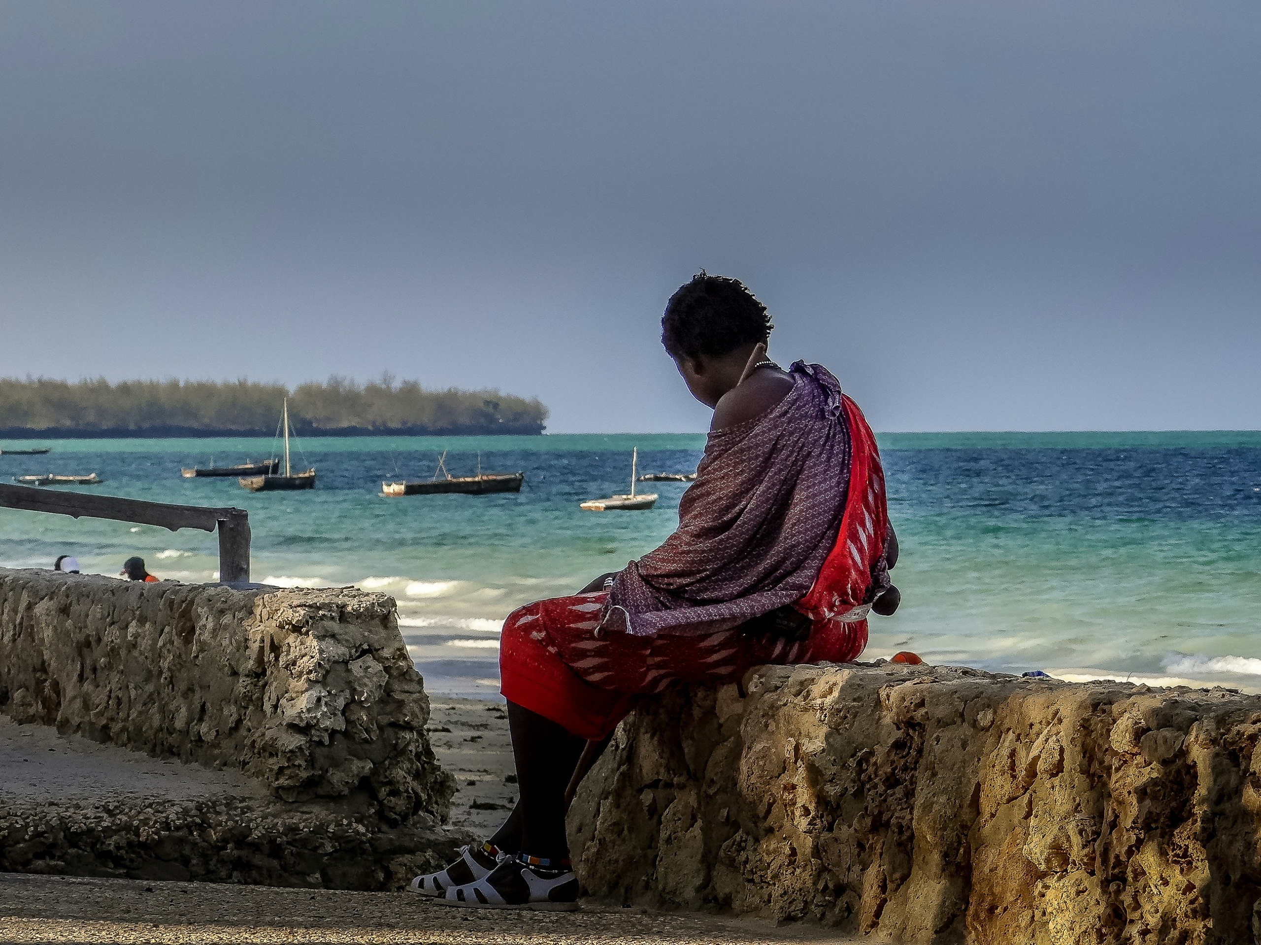 Zanzibar harbour with local woman and traditional dhow boats